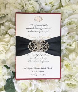Red silk wedding invitation in ivory with brooch